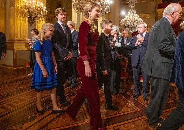 Queen Mathilde wore a floral print gown by Dries Van Noten. Crown Princess Elisabeth wore a velvet-satin jumpsuit by DVF