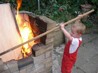 prodding a bonfire with a broomstick