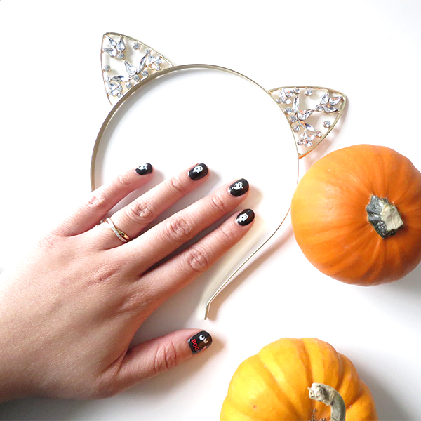 Halloween-inspired manicure with black nail polish and white ghosts using Kiss Nail Art Stickers Halloween Edition