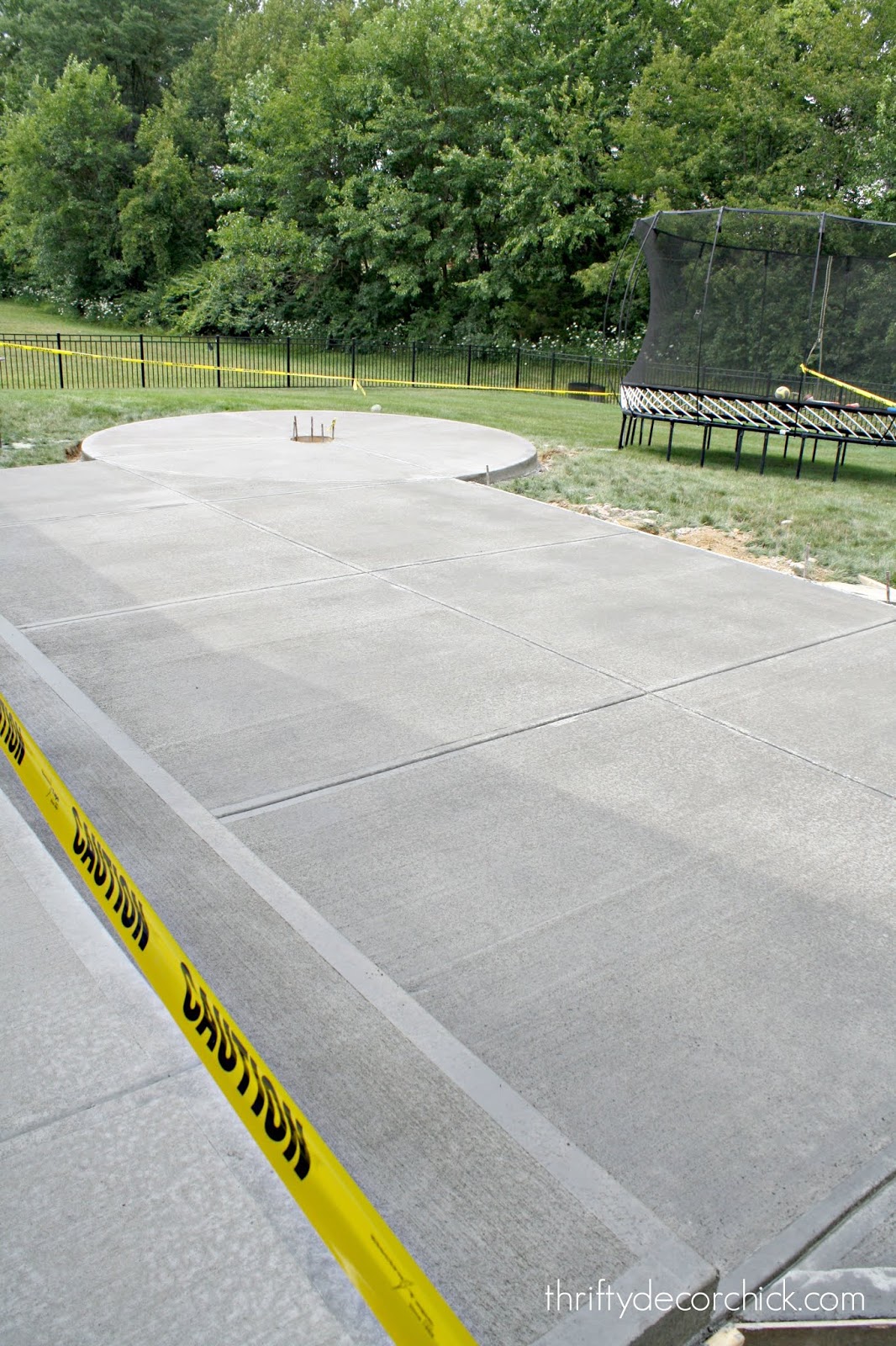 Large concrete patio with round fire pit seating 