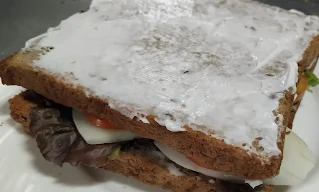 Vegetables topped bread slice cover with mayonnaise spread bread slice for veg club sandwich recipe