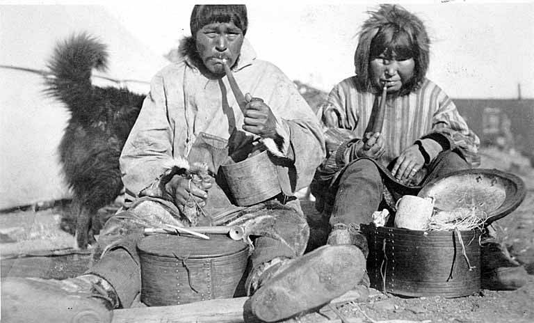 Eskimo_couple%252C_smoking_pipes%252C_seated_beside_carved_wooden_boxes_and_tools%252C_location_unknown%252C_ca_1899_%2528WARNER_450%2529.jpg
