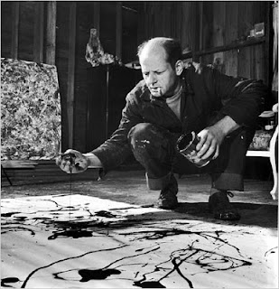 Jackson Pollock painting with a cigarette hanging from his lips.