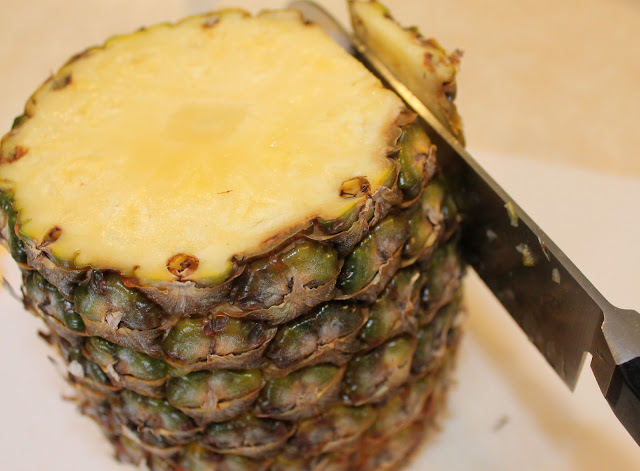 Cut the skin from the sides of the pineapple with a sharp knife. The Second Step in Preparing a Fresh Pineapple is to Slice the Skin.