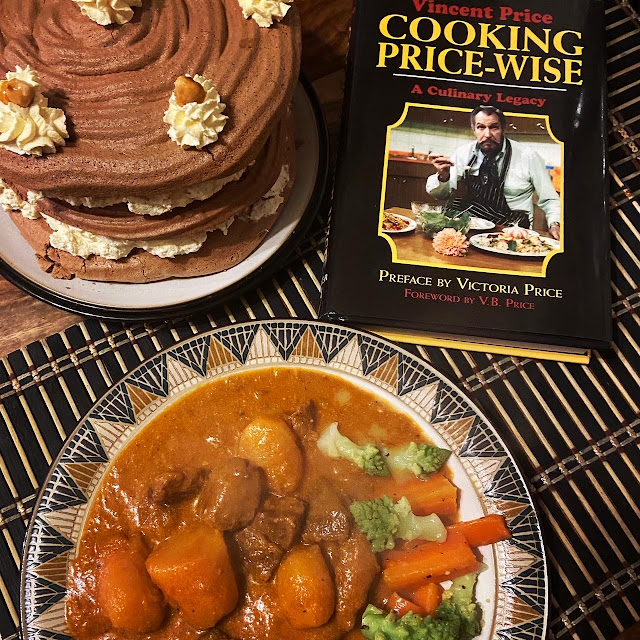 A chocolate cake and a plate of beef and potato goulash next to a copy of the book Cooking Price-Wise