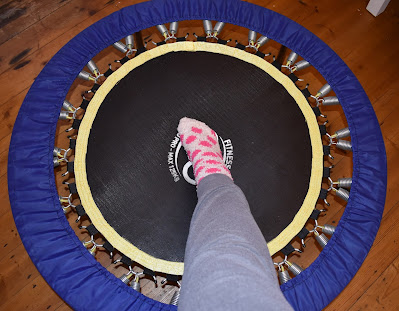 rebounder exercise equipment with foot on it to show size comparison
