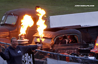 Stefanie Lea raises her arms to signal the rat rods to start burning their tires.