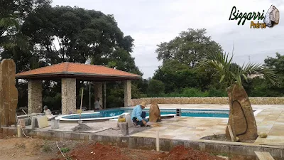 Execução de revestimento de pedra, com pedras do rio, sendo o revestimento nos pilares com o piso de pedra São Tomé amarelo.