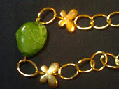 pulseira dourada c pedra verde e borboleta