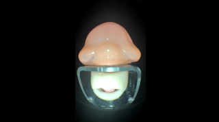 Amnesia Scanner's visuals of a human-like machine mouth with a nose, cheeks, and  eyes