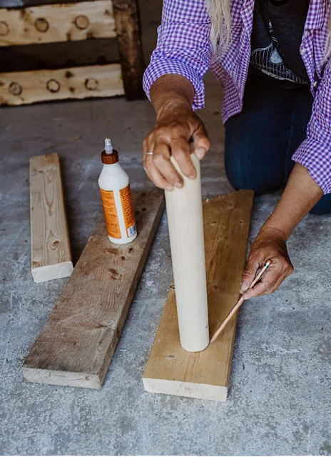 woman gluing dowels to board