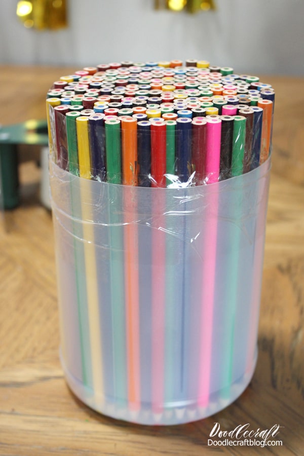 Then use some clear packing tape and wrap it around the container and the tops of the colored pencils.