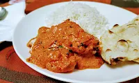 Serving butter chicken with rice and naan
