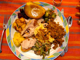 photo of a typical Thanksgiving dinner plate of mashed potatoes, stuffing, turkey, and vegetable sides