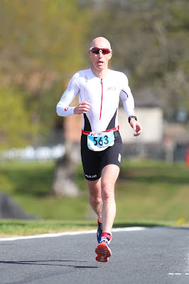A picture of a bald man in sun glasses running