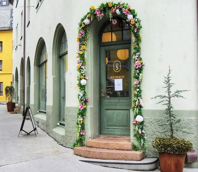 Green Art Nouveau door with floral trim in Alesund Norway