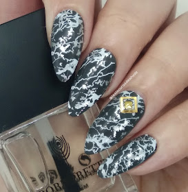 nail art con efecto marmol en colores gris y blancos, anular decorado con dos piezas doradas
