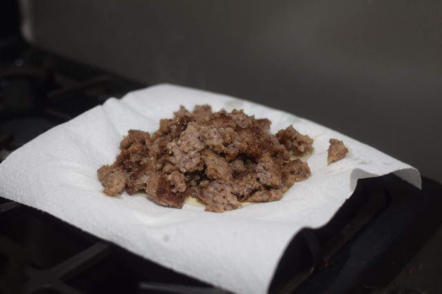 The browned sausage draining on a paper towel. 