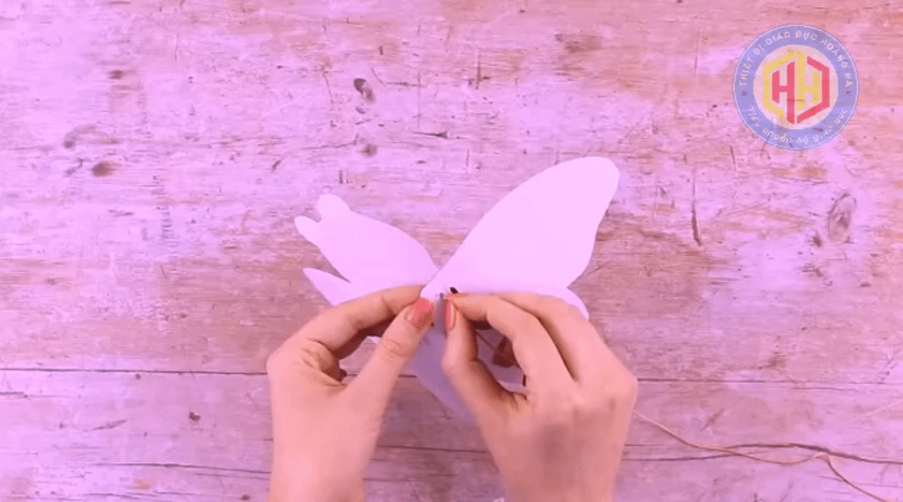 Nhấn vào ảnh để phóng to Xỏ dây qua lỗ trên cánh (chấm đen) và luồn qua lỗ trên cánh còn lại.