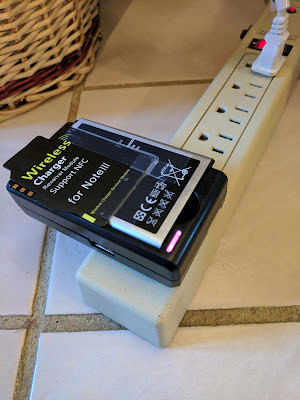 The Battery Charger does not Interfere with the Card Taped to the Battery. The external battery charger does not interfere with the wireless receiver coil card taped to the spare battery.