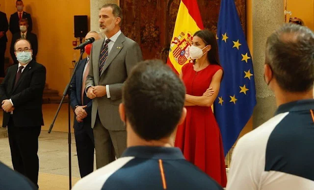 Queen Letizia wore a red sleeveles midi dress, and red suede high heel slingback pumps from Carolina Herrera, and Gold&Roses Joyas earrings