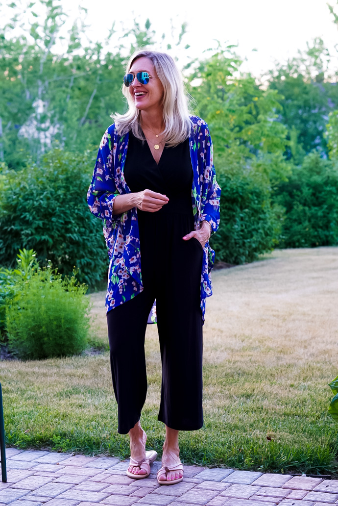 A woman wears a blue kimono over a black jumpsuit