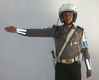 Menghentikan arus kendaraan dari arah belakang petugas