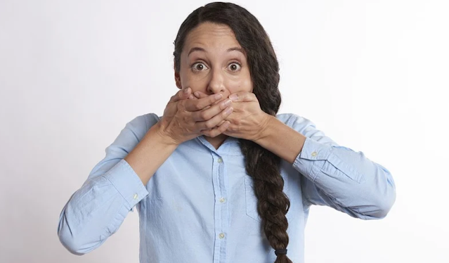 Woman with hands over mouth