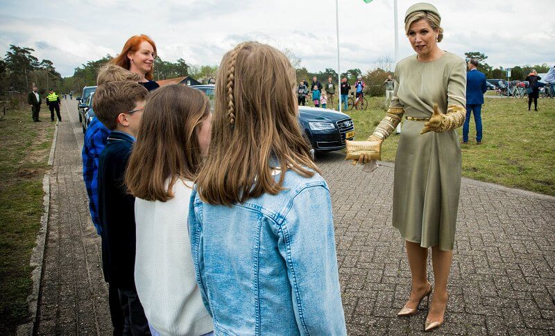 Queen Maxima wore an embellised draped midi dress by Claes Iversen. Gianvito Rossi gold plexi pumps. Begum Khan clutch bag