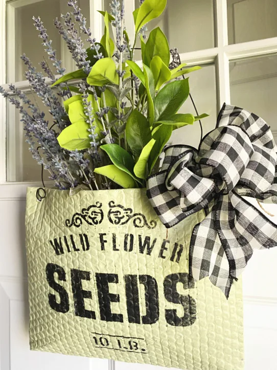 flower basket on the front door with flowers and a bow