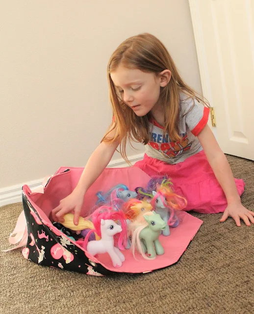 Little girl with fold out toy box and ponies