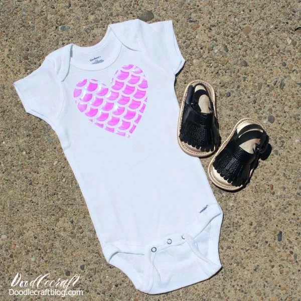 Pink Shimmering Holographic Mermaid Scales cut in a Heart shape and ironed on a Onesie with Cricut EasyPress 2.