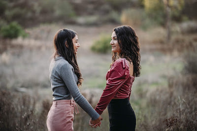 Teenage sisters holding hands posing for portrait for Christmas mini sessions with Morning Owl Fine Art Photography located in San Diego. 