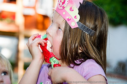 Birthday girl taking a bite of Shrawberry Shortcakes face.
