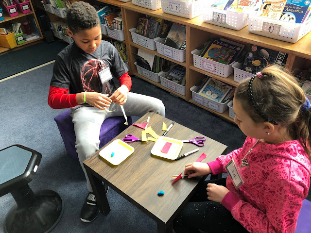 kids in library making sailboats
