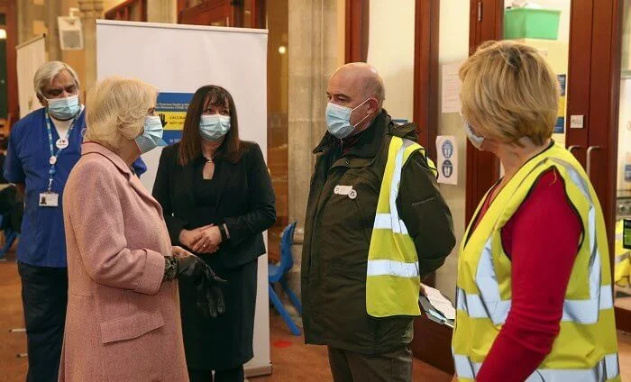 The Duchess met with those involved in the vaccination process, including NHS staff, volunteers and representatives. Pink wool coat and black boot