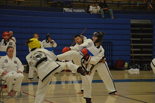 Two teenage girls sparring in a martial arts class