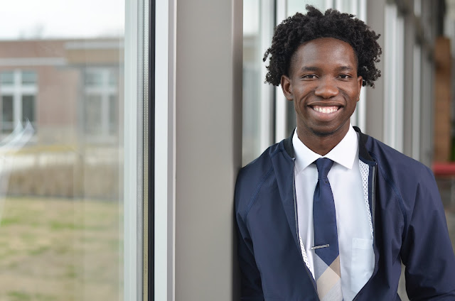 man standing next to window