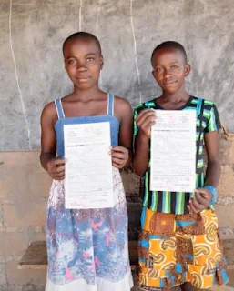 Sisters displaying birth certificates in Cameroon Africa.