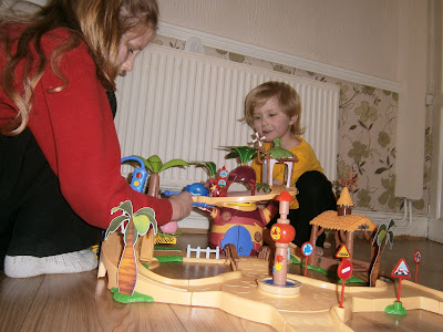 two older children playing with the jungle junction playset from flair
