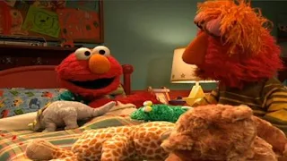 Louie begins to put Elmo in his bed. Sesame Street Bedtime with Elmo