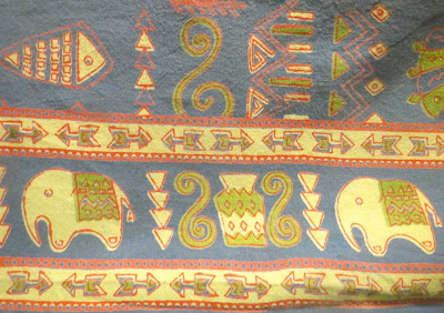 Tablecloth in blue, green, red, and cream with elephants and arrow border