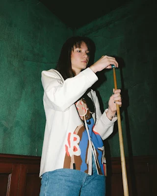 A lady applying chalk at the tip of a cue stick