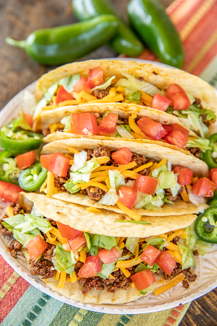 The BEST Taco Meat - our go-to recipe for taco night. Tastes as good as our favorite Mexican restaurant! Super easy to make and ready to eat in about 15 minutes. Ground beef, onion, garlic, chili powder, salt, cumin, diced tomatoes and green chiles, red pepper flakes, and water. You will never use a packet of taco seasoning again! Can freeze leftovers for a quick meal later. A must for taco night! #taco #groundbeef #mexican #tacomeat tacos on a plate