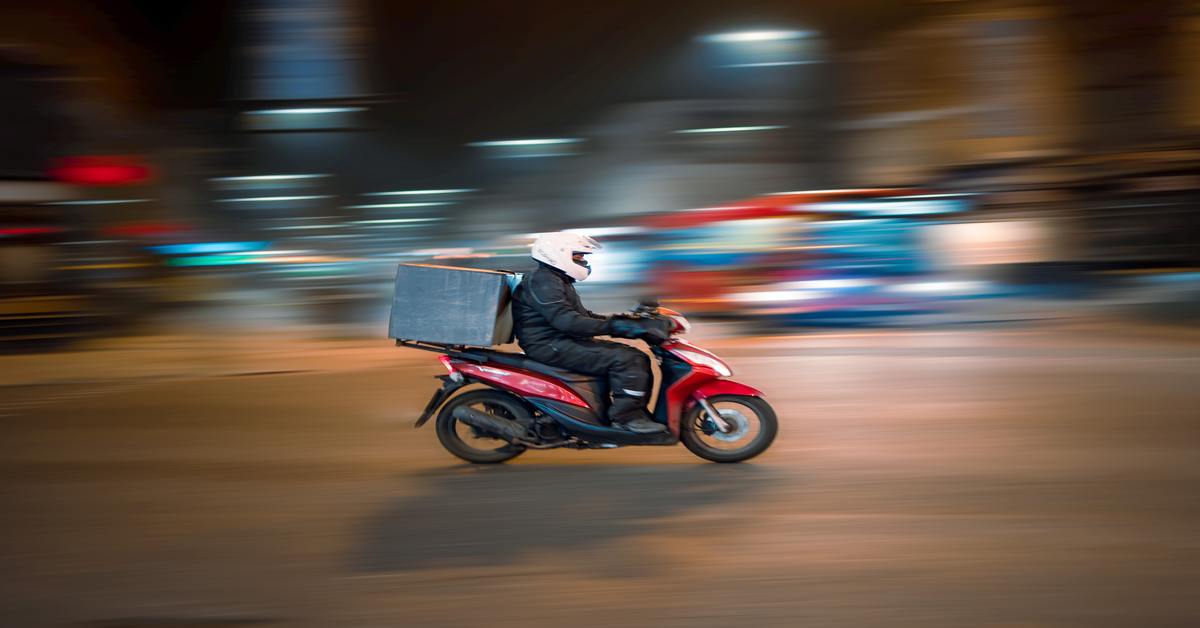 a food delivery boy on his scooter going for food delivery a food delivery boy on his scooter going for food delivery