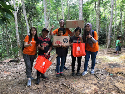 Veveonah Mosibin (center) together with her parents are happy to receive the Shopee Care Package from the Shopee team at her village in Kg Sapatalang, Pitas, Sabah