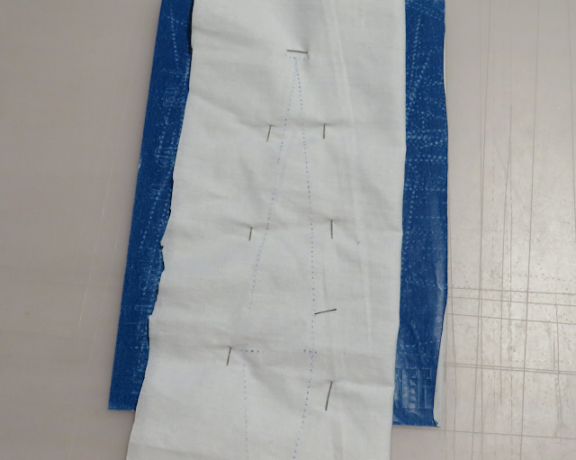 Tela colocada sobre el papel de calco para marcar pinza por el otro lado