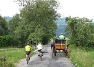 Cyclists passing a horse-drawn carriage, Liechtenstein.