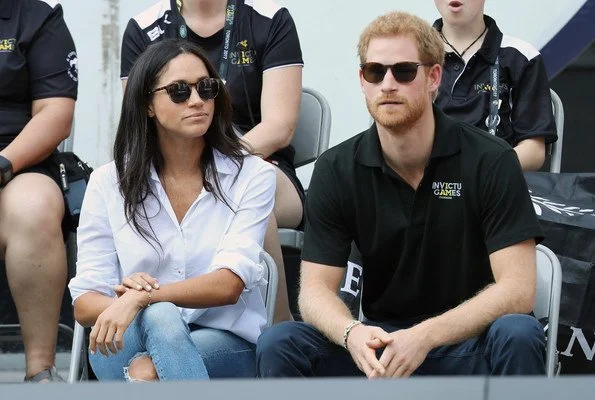 Prince Harry and Meghan Markle watched Wheelchair Tennis match. Style of Meghan Markle. wore a ice blue blouse and jeans