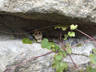 A close up picture of a small, ceramic Skull, Skulferatu #51, in a gap in the medieval wall near the Multangular Tower in the Museum Gardens in York.  Photo by Kevin Nosferatu for the Skulferatu Project.